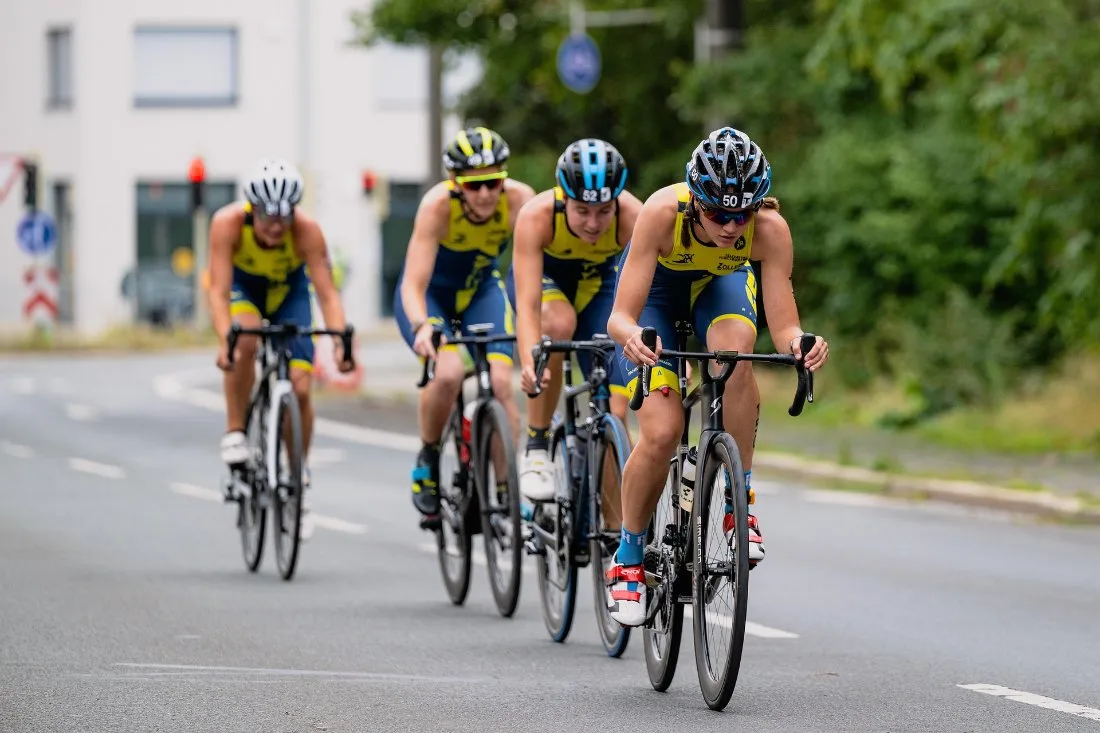 A pack of cyclists racing in a triathlon